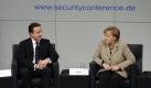Kanzlerin Angela Merkel und der britische Premierminsiter David Cameron sitzen am Podium der Münchner Sicherheitskonferenz. Foto: dpa