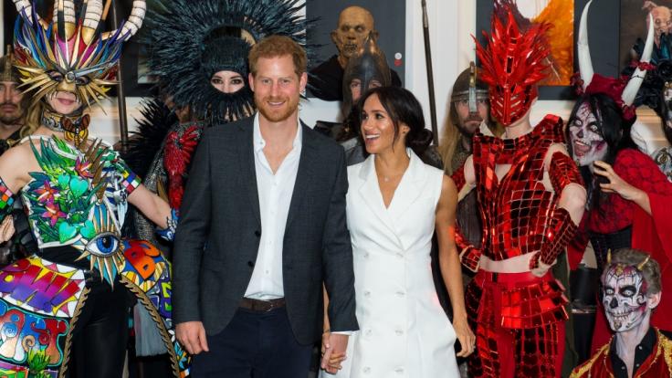 Inmitten der zu Halloween kostümierten Gestalten sehen Prinz Harry und seine schwangere Ehefrau Meghan Markle beinahe farblos aus.