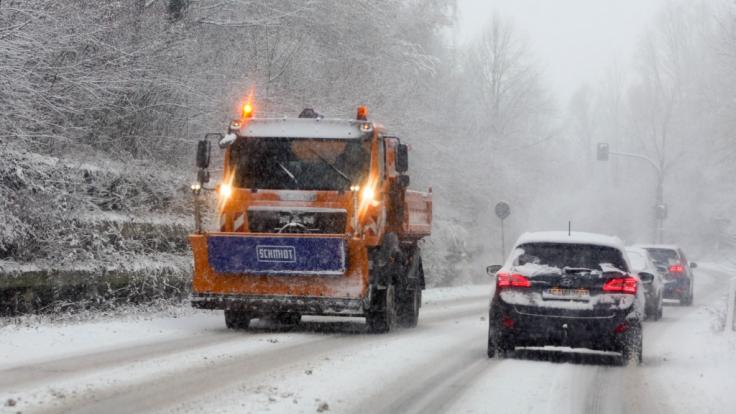 Ein Streufahrzeug befährt eine verschneite Strasse bei Aachen.