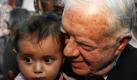 Der ehemalige US-Präsident Jimmy Carter trägt ein palästinensisches Kind während eines Besuchs in dem Unruheherd Silwan östlich von Jerusalem, wo er sich mit palästinensischen Residenten trifft. Carter ist Teil einer Delegation von älteren ehemaligen Prominenten, die in Palästina unterwegs sind. Foto: dpa