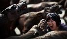 Eine Touristin posiert vor einer Wolfsskulptur des chinesischen Künstlers Liu Ruowang in einem Kunstviertel in Peking. Foto: ap