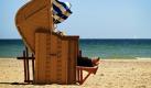 Die nackten Füße einer Urlauberin sind am Strand von Travemünde in einem Strandkorb zu sehen. Nach einem frühlingshaften Wochenende lässt Tief Queenie die Temperaturen in den kommenden Tagen wieder sinken. Foto: ddp
