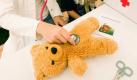 Medizinstudentin Katja untersucht in der Teddyklinik des Universitätsklinikums in Magdeburg den Teddybären von Jonas. Bis Freitag erwarten angehende Mediziner rund 500 Kindergartenkinder, denen gezeigt wird, wie gebrochene Puppenärmchen geheilt und aufgerissene Nähte versorgt werden. Ziel der Teddyklinik ist es, Kindern die Angst vor Arztbehandlungen und Krankenhausaufenthalten zu nehmen. Foto: dpa
