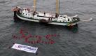 Rund 50 Greenpeace-Aktivisten bilden in der Ostsee vor Fehmarn neben der «Beluga» schwimmend das internationale Seenotkürzel SOS. Daneben ist ein Transparent mit der Aufschrift «Rettet unsere Meere» zu sehen. Die Aktivisten demonstrieren für den Schutz von Schweinswalen und für eine Erneuerung der europäischen Fischereipolitik.  Foto: dpa