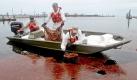 Arbeiter filtern per Hand Öl verschmutztes Wasser in Gulfport. Knapp zehn Wochen nach Beginn der Ölkatastrophe im Golf von Mexiko hatte das Öl erstmals auch die Küste des US-Staates Mississippi erreicht.  Foto: ap