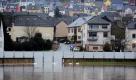 Schwaene schwimmen am Freitag (07.01.11) im Hochwasser der Mosel vor Wohnhaeusern in Oberbillig in Deutschland, die von einer Hochwasserschutzmauer geschuetzt sind, aufgnommen von Wasserbillig aus, auf der luxemburgischen Seite. Tauwetter und Regen haben am Freitag die Pegel vieler Fluesse stark ansteigen lassen. In Rheinland-Pfalz wiesen vor allem Rhein, Mosel, Lahn und Nahe stark steigende Pegel auf. In Koblenz richtet sich die Berufsfeuerwehr auf das schlimmste Hochwasser seit zehn Jahren ein. (zu dapd-Text) Foto: Harald Tittel/dapd Foto: ddp