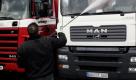 Ein Mann reinigt am Montag (20.11.06) auf dem Hof eines Scania-Haendlers in Hochheim am Main zwei Lastkraftwagen der Marken Scania und MAN mit einem Hochdruckreiniger.
 Foto: ddp