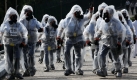 Polizisten tragen weiße Schutzkleidung bei einer Übung zur Abwehr biologischer, chemischer, radioaktiver und nuklearer Katastrophen.Sie dient der Vorbereitung der East Asian Games, die ab dem 5. Dezember in Hong Kong stattfinden werden. Foto: ap