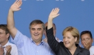 Peter Müller (CDU), Ministerpräsident des Saarlandes, winkt zusammen mit Bundeskanzlerin Angela Merkel beim Familienfest der CDU-Saar am Bostalsee in Bosen den Besuchern zu. Foto: dpa