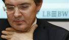 ARCHIV - Siegfried Jaschinski, Vorstandsvorsitzender der Landesbank LBBW fasst sich am 21. November 2008 auf einer Pressekonferenz in Stuttgart an den Hals. Wegen des Verdachts der schweren Untreue haben Hunderte Beamte am Montag, 7. Dez. 2009, die Landesbank Baden-Wuerttemberg durchsucht. Gegen den frueheren Vorstandschef Siegfried Jaschinski und sechs amtierende Vorstaende leitete die Staatsanwaltschaft Stuttgart ein Ermittlungsverfahren ein. (AP Photo/Thomas Kienzle, File) -- FILE - Siegfried Jaschinski, CEO of Landesbank Baden-Wuerttemberg, LBBW, bank is seen on a press conference in Stuttgart, Germany, Nov. 21, 2008. (AP Photo/Thomas Kienzle) Foto: ap