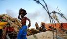Plünderer tragen Erbeutetes in der haitischen Hauptstadt Port-au-Prince in Sicherheit. Eine Woche nach dem verheerenden Erdbeben ist die Lage in Haiti noch immer chaotisch - ein weiteres starkes Beben spannt die Lage zusätzlich an.  Foto: ap