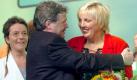 In den Armen liegen sich die neuen Vositzenden von Bündnis 90/Die Grünen, Claudia Roth (r) und Reinhard Bütikofer ( M), am Sonnabend (02.10.2004) in der Ostseehalle in Kiel auf der Bundesdelgiertenversammlung der Partei, nachdem sie im Rahmen der Vorstandswahlen in ihre Ämter gewählt worden waren. Die Delegierten von Bündnis 90/Die Grünen wählen auf ihrem zweitägigen Parteitag bis Sonntag (03.10.2004) einen neuen Vorstand. Roth löst Angelika Beer (l) als Parteivorsitzende ab, die als Abgeordnete in das Europaparlament geht. Foto: Tim Brakemeier dpa  Foto: dpa