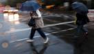 Passanten eilen unterm Regenschirm durch Berlin. Foto: Michael Kappeler Foto: dpa