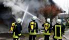 Einsatzkräfte der Feuerwehr versuchen am Freitag einen Brand in einem Einfamilienhaus in Rückeroth im Westerwaldkreis zu löschen. In dem Gebäude lebt eine Familie, nach der am Vormittag noch gesucht wurde. Foto: dapd