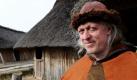 Schleswig. Reinhard Erichsen steht in Wikingerkleidung auf dem Freigelände des Wikingerdorfes am Wikingermuseum Haithabu. Am Wochenende startet die neue Saison für die Besucher der, an ihrem historischen Platz, originalgetreu nachgebauten Wikingersiedlung. Foto: dpa