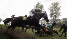 Der tschechische Jockey Josef Pana beim Sprung über die Irische Bank beim 119. Steeplechase-Pferderennen im ostböhmischen Pardubice. Das Rennen steht in der Kritik vieler Tierschützer, da sich viele Pferde bei den ungewöhnlich schweren Hindernissen verletzen.  Foto: ap