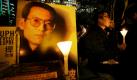 Pro-demokratische Demonstranten in Hong Kong halten Kerzen und unterstützen damit den inhaftierten chinesischen Dissidenten Liu Xiaobo, der auf dem Poster zu sehen ist. Das norwegische Nobelkommitteee hat entschieden, dass Liu den Friedensnobelpreis für seinen langen und gewaltlosen Kampf für fundamentale Menschenrechte in China erhält. Foto: dapd