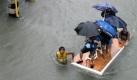 Commuters are ferried on an improvised raft following floodings brought about by tropical storm Ketsana (locally known as Ondoy) Saturday Sept. 26, 2009 in Manila, Philippines. Nearly a month's worth of rain fell in just six hours Saturday on the Philippine capital, stranding thousands on rooftops in the city and elsewhere as Tropical Storm Ketsana slammed ashore. (AP Photo/Bullit Marquez) Foto: ap