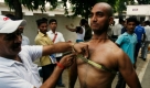 Ein Polizeibewerber lässt sich seinen Brustumfang in Allahabad, Indien, vermessen. Das geschieht im Rahmen einer landesweiten Rekrutierungsmaßnahme, um 35.000 offene Polizistenstellen zu besetzen. Foto: ap