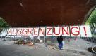 Eine Passantin liest die Protestplakate unter einer Brücke in der Helgoländer Allee in Hamburg. Im Schutz der Brücke hatten jahrelang Obdachlose übernachtet, bis das Bezirksamt jüngst für 18.000 Euro einen rund 20 Meter langen Zaun errichten ließ. Er soll verhindern, dass Wohnungslose dort kampieren. Foto: dpa