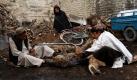 Afghanische Männer sägen ein Stück Holz in Kandahar, um es besser verheizen zu können. Foto: ap