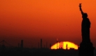 The sun sets behind the Statue of Liberty in New York, Sunday, Nov. 8, 2009. (AP Photo/Benny Snyder) Foto: ap