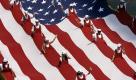 Fans laufen in eine riesige amerikanische Flagge eingehüllt in der Parade zur Eröffnung des 500-Meilen-Rennens von Indianapolis im US-Bundesstaat Indiana. Foto: ap