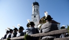 In Trachten gekleidete Musiker sitzen während der Leonhardifahrt in Pähl (Landkreis Weilheim-Schongau) auf einem Wagen und fahren mit ihren Blechblasinstrumenten an der Dorfkirche vorbei. Die traditionelle Wallfahrt zu Ehren des Heiligen Leonhard, des Schutzpatrons der landwirtschaftlichen Tiere, findet jährlich in zahlreichen Orten Oberbayerns statt. Foto: dapd