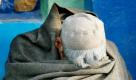 An Afghan beggar shields himself from an early morning chill, outside a mosque in Kabul, Afghanistan, Wednesday, Sept. 15, 2010. (AP Photo/ Mustafa Quraishi) Foto: ap