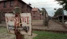 ARCHIV - 'Vorsicht, Hochspannung' steht auf einem Schild vor der Stacheldrahtabsperrung des ehemaligen Konzentrationslagers Auschwitz (Archivfoto vom 12.07.1998). 64 Jahre nach Kriegsende ist das Interesse an Auschwitz, dem weltweiten Holocaust-Symbol, größer denn je zuvor. Mehrere tausend Menschen aus aller Welt gehen täglich durch das berühtigte Eingangstor mit der zynischen Aufschrift «Arbeit macht frei» in die Gedenkstätte auf dem Gelände des ehemaligen deutschen Konzentrations- und Vernichtungslagers im südpolnischen Oswiecim. Doch in der Alltagsarbeit der Gedenkstätte hatte es seit einiger Zeit immer mehr Anlass zur Sorge gegeben, bis Direktor der Einrichtung Piotr Cywinski öffentlich den Alarm schlug. Der Gedenkstätte drohe der Verfall, erklärte er. Foto: Jens Kalaene (zu dpa-KORR: 'Polen ruft nach Hilfe für Gedenkstätte Auschwitz ') +++(c) dpa - Bildfunk+++
 Foto: dpa