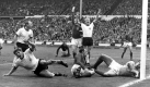 Fußball-Nationalspieler Wolfgang Weber (l) jubelt nach seinem Treffer zum 2:2 beim Weltmeisterschaftsfinale Deutschland - England im Wembley-Stadion in London. (Archivfoto vom 30.7.1966) Mit Weber jubeln Uwe Seeler (l) und Karl-Heinz Schnellinger (2.v.r.). Am Boden liegen Jack Charlton (M) und Torhüter Gordon Banks (r). Der damals 22-Jährige Weber feiert am Samstag (26.06.) seinen 60. Gebuirtstag. Von 1962 bis 1977 spielte er für den 1. FC Köln und galt als bester deutscher Vorstopper der 60er Jahre. Wegen seiner Kraft, seines Kampfeswillens und seiner Ausdauer erhielt er denSpitznamen 'der Bulle'. dpa/lnw (zum Korr. vom 25.06.2004: 'Immer das Herz der Mannschaft - Wolfgang Weber wird 60') Foto: dpa