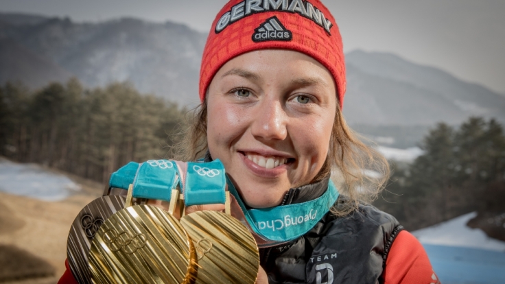 Laura Dahlmeier zeigt stolz ihre drei olympischen Medaillen.
