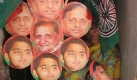 A supporter of Samajwadi Party holds party flags and masks of party leaders Mulayam Singh Yadav and Akhilesh Yadav in Allahabad, India, Tuesday, April 21, 2009. India's national elections, which began Thursday will take place over five phases until May 13. (AP Photo/Rajesh Kumar Singh) Foto: ap