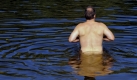 Ein Badegast steht in Berlin im Teufelssee. Die warmen Temperaturen bleiben Deutschland in den kommenden Tagen noch erhalten. In der Regel liegen die Hoechstwerte über 20 Grad, im Osten teils sogar um 25 Grad, teilte der Deutsche Wetterdienst mit. Foto: ddp