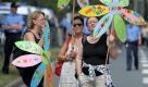 Teilnehmer einer Gegendemonstration gegen das Rechtsrock-Festival Rock für Deutschland halten in Gera in der Nähe des Veranstaltungsgeländes Schilder in Form von Blumen in die Höhe. Mehrere Hundert Demonstranten haben in Gera weitgehend friedlich gegen das NPD-Festival protestiert. Rund um das Konzertgelände auf der Spielwiese beteiligten sich schätzungsweise 800 Personen an den Kundgebungen, wie die Polizei mitteilte. Foto: dapd