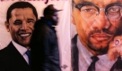 A man walks past murals of Democratic presidential candidate Sen. Barack Obama, D-Ill., left, and Malcom X, right on election day Tuesday, Nov. 4, 2008, in the Harlem section of New York. (AP Photo/Frank Franklin II) Foto: ap