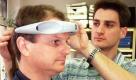 Eine neuartige Mobiliätshilfe für Blinde und Sehschwache testen Geschäftsführer Ulrich Scholz (l) und Mitarbeiter Andre Schwolow am 15.02.2000 in der Obrira Optik Brillen GmbH Rathenow. Das aus einem Stirnteil und einem um den Hals zu tragenden Akku bestehende Gerät 'Sensix' kann Objekte und Hindernisse im Abstand von 4,5 Metern auf Ultraschall-Basis orten und über sechs im Stirnband befindliche Vibratoren Rechts- oder Links-Klopfzeichen in zu oder abnehmender Stärke an den Kopf des Trägers weiterleiten, ohne dass die Ohren als wichtigstes Wahrnehmungsorgan verdeckt werden. Nach der Testphase soll die Brandenburger Weltneuheut im April auf den Markt kommen. dpa/lbn  Foto: dpa