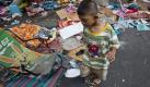 A young scavenger collects abandoned anti-government clothing from a rally site Saturday, May 22, 2010, in Bangkok, Thailand. Thailand's Prime Minister Abhisit Vejjajiva made an appeal for the nation on Friday to heal the political wounds but senior advisors said the pressure for him to call elections is increasing. (AP Photo/David Longstreath) Foto: ap