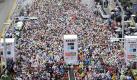 Tausende Läufer bevölkern die Straße vor dem Rathaus in Tokio, Japan, und warten auf den Start des Marathons. Foto: ap