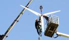 Architekt Wolfgang Frey (links) montiert in Freiburg ein kleines Windrad auf die Spitze eines 25 Meter hohen Strommastes. Mit der Windkraftinitiative Free Energy will Frey das Platzproblem für neue Windräder lösen. Strommasten könnten eine doppelte Funktion erfüllen: Stromleitungen und leicht zu montierende Windräder tragen und damit dezentral Energie produzieren helfen.  Foto: dapd