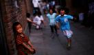 Ein chinesischer Junge auf einer Straße in Peking schaut zu, wie andere Kinder Fangen spielen. Foto: ap