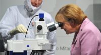 Bundeskanzlerin Angela Merkel, rechts, schaut am Mittwoch, 22. Oktober 2008, zu Beginn des Bildungsgipfels beim Chiphersteller AMD in Dresden durch ein Elektronenmikroskop.