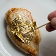 Hier wird gerade Blattgold auf ein Stück Fleisch aufgetragen. Hier wird gerade Blattgold auf ein Stück Fleisch aufgetragen.