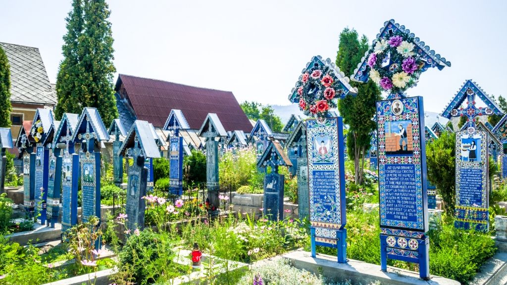 Auf dem "Fröhlichen Friedhof" in der Gemeinde Săpânța in Rumänien sucht man graue Grabsteine vergebens. Die rund 800 Holzkreuze sind stattdessen bunt bemalt und zeigen Szenen aus dem Leben der Verstorbenen. (Foto)