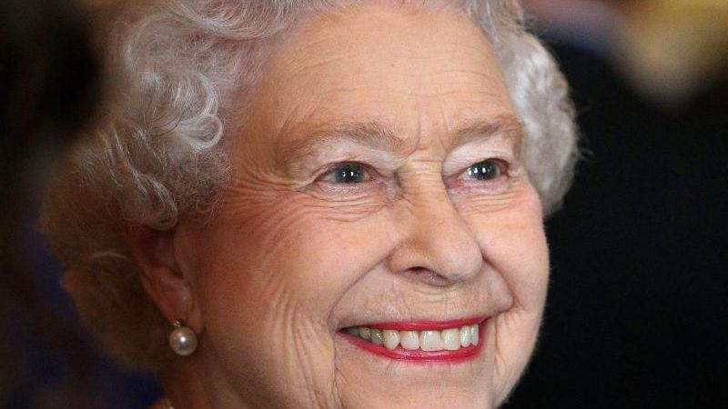 Queen Elizabeth II. tritt nie ohne ein wichtiges Accessoire aus dem Haus: ihren Lippenstift. In Kombination mit ihrem strahlenden royalen Lächeln kommt die korallene Lippenfarbe besonders gut zur Geltung. (Foto)