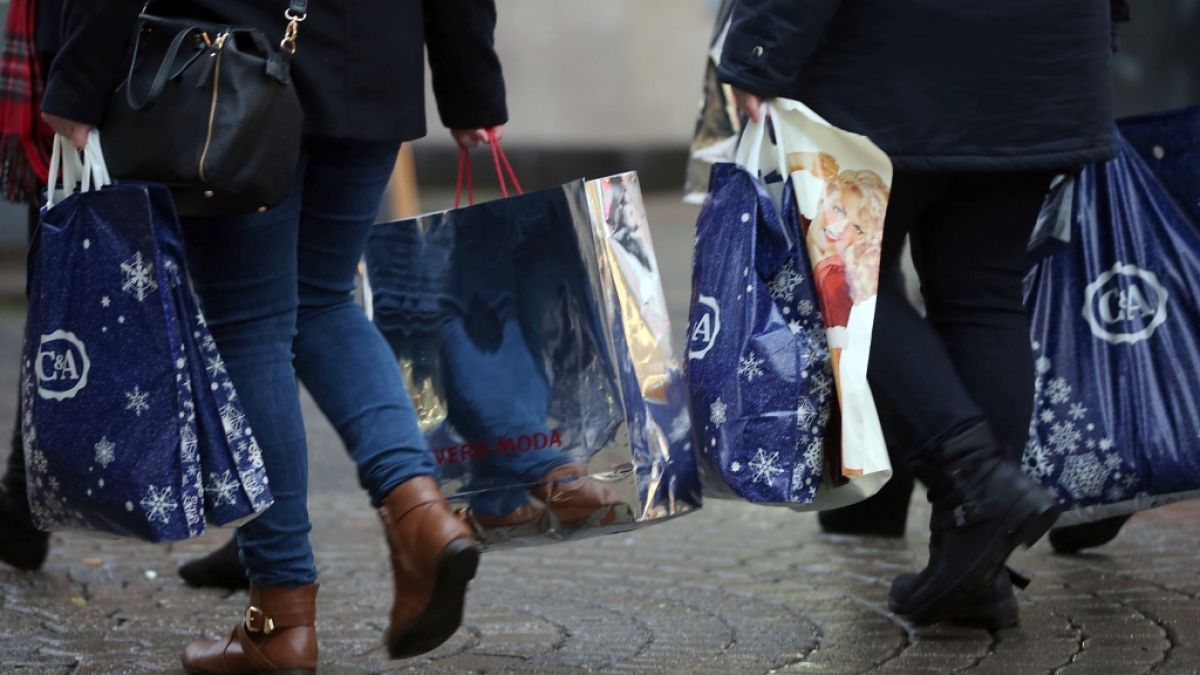 Passanten mit Taschen voller Weihnachtseinkäufe, unter anderem von CA, in der Fußgängerzone von Köln. (Foto)