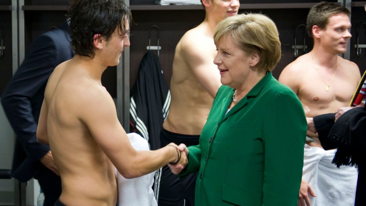 Oben ohne vor dem Staatsoberhaupt: Angela Merkel gratuliert Mesut Özil nach einem Sieg in der Kabine. (Foto)