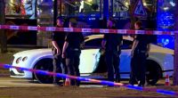 Polizisten stehen neben dem Auto auf dem Hamburger Millerntorplatz, nachdem Schüsse auf den Fahrer abgegeben wurden.