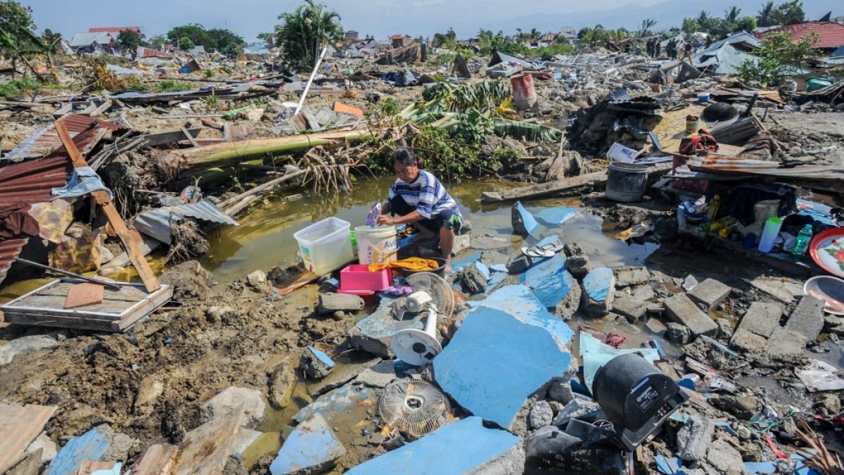 Indonesien, Palu: Agustin (51) wäscht nach dem Erdbeben Wäsche zwischen den Ruinen seines Hauses im Dorf Balaroa. (Foto)