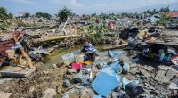 Indonesien, Palu: Agustin (51) wäscht nach dem Erdbeben Wäsche zwischen den Ruinen seines Hauses im Dorf Balaroa.